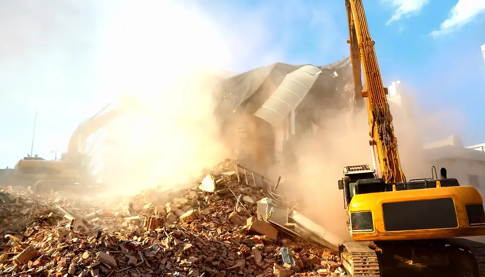 Excavator demolishing a commercial property, illustrating early-stage site clearance and debris removal
