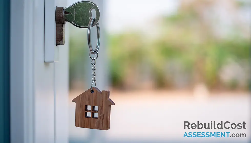 House key with a wooden house-shaped keyring in a door lock, representing homeownership and building insurance for mortgage requirements.